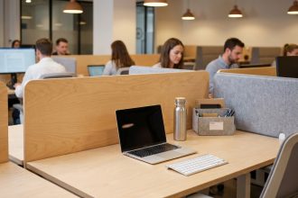 Bureau partagé bien rangé dans un espace de coworking avec organiseur de bureau, laptop et accessoires minimalistes