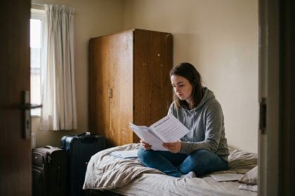 Jeune femme examinant un contrat dans une chambre partagée